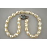 A single row of large baroque cultured pearls on white metal snap stamped 925, set blue stone