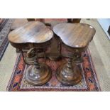 A pair of reproduction stained wood occasional tables with shaped triangular tops,