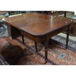 An early Victorian mahogany dining table, the pair of ends with rounded corners raised on turned