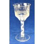 An Edwardian wine goblet, the large ogee bowl engraved with a frigate and a woman emerging from