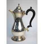 A silver baluster coffee pot in the Georgian style, with flame finial, gadrooned rims and