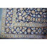 A large Kashan carpet, traditional design with central floral motif on navy blue ground with