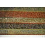 A late 1900s Arts & Crafts influenced woven wool throw worked in 12 cm narrow strips with foliate
