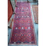 A Persian Balouch rug the red and blue ground with diamond/lozenge design, 250 x 95 cm