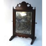 A small mahogany swing toilet mirror with bevelled plate and fret-cut crest