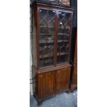 A mahogany cabinet bookcase of small proportions with moulded cornice above twin glazed doors and