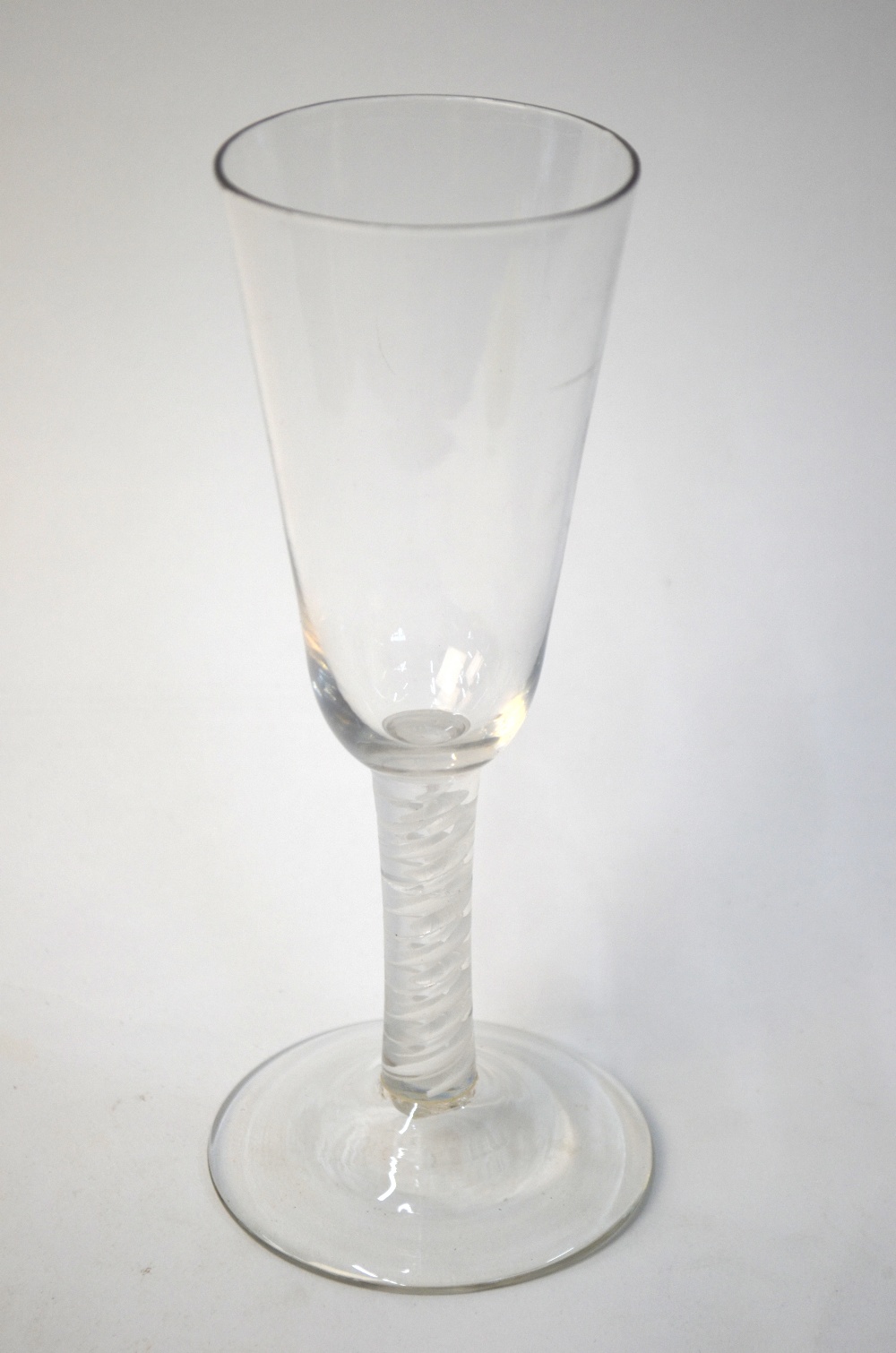 An 18th century ale glass, rounded funnel bowl, multiple spiral opaque twist stem, domed foot and