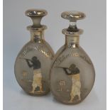 A pair of US frosted glass dimple decanters and stoppers inlaid in silver with a man with rifle