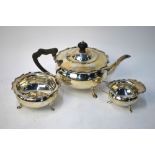 An Edwardian heavy quality silver three-piece tea service of compressed melon form with shaped rims,