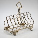 A Victorian silver six-division toast rack with Gothic-Revival decoration, on cast scroll feet,