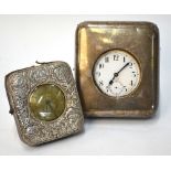 A watch-stand with embossed silver foot, containing a Victorian silver pocket watch with silvered