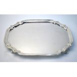 A silver salver of elongated octagonal form, on scroll feet, Harrods Ltd., Birmingham 1939, 24.8 oz,