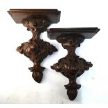 A pair of carved oak wall brackets with foliate decoration,