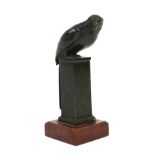 A dark brown patinated bronze parrot perched on a pedestal, stamped 'Reiter Munchen', on red