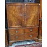 A George III mahogany low linen press with twin panelled doors enclosing sliding shelves, two