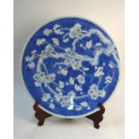 A Chinese or Japanese blue and white dish, decorated with a prunus design, 42 cm diameter,