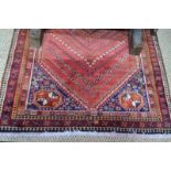 A South West Persian Shiraz rug, the geometric design central lozenge on ochre ground within