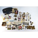 An assorted quantity of military and other insignia including WWI / WWII and later cap,