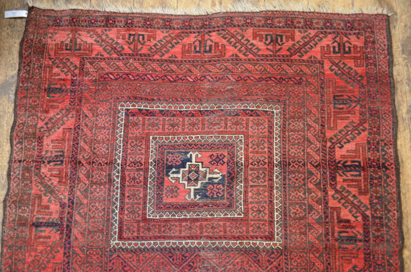 A worn Afghan rug, the central reserve w