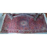 A Persian Bidjar wide runner with large central blue and ivory medallion on wine ground decorated