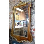 A George III burr walnut and parcel gilt mirror, surmounted by a shell motif,