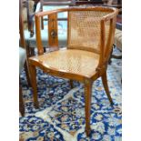 A Sheraton style caned satinwood chair with polychrome floral decoration and serpentine form seat,