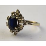 An oval sapphire and diamond cluster ring, the central sapphire with diamonds around,