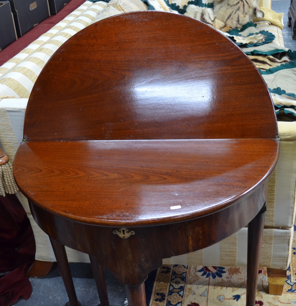 An 18th century mahogany demi-lune fold over gateleg table with storage well raised on four turned - Image 2 of 3