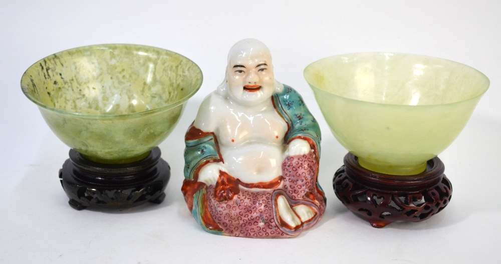 Two Chinese, semi-translucent mottled-green stone bowls; each one on a circular foot.