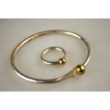 A contemporary silver bangle with ball terminal and matching ring to/w white metal adjustable