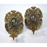 A pair of Baroque gilt metal sconces, cast and cased with brazier flanked by cherubs,