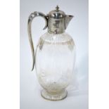 A Victorian ovoid cut glass claret jug with silver collar, cover, handle and foot,