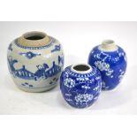 Three blue and white ginger jars; two decorated with prunus and one decorated with boys;