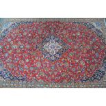 A Persian rug, the gold central medallion within a mauve cartouche on dark blue ground with gold,