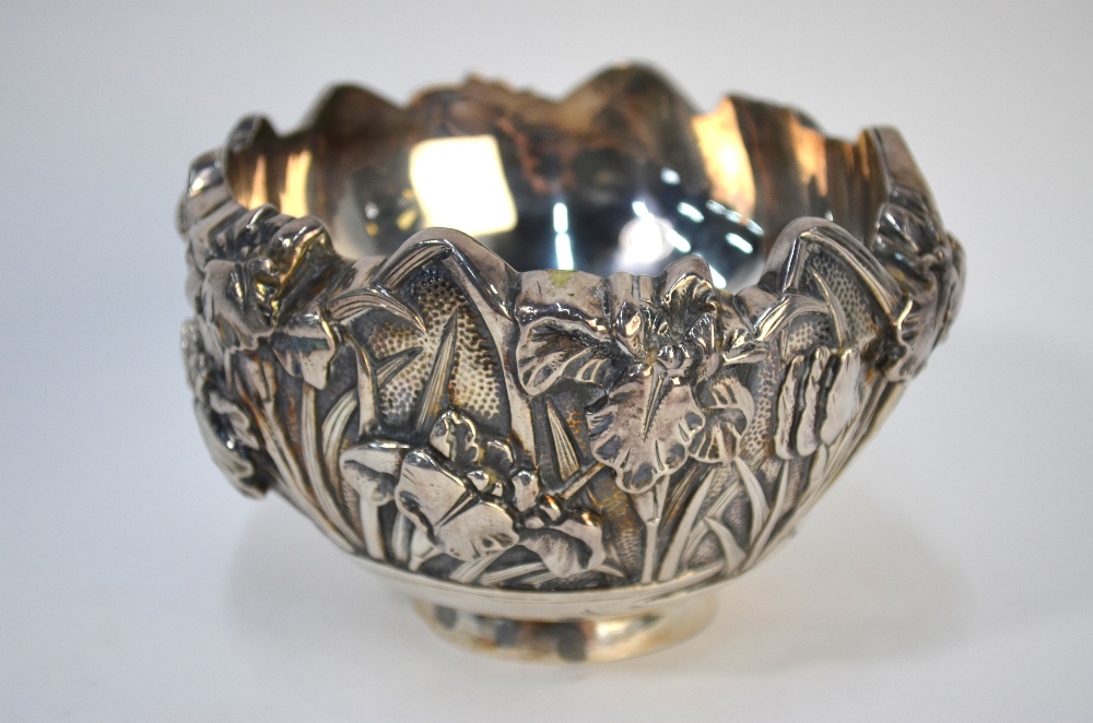 A Japanese white metal bowl, decorated on the exterior with a floral design; 13cm diameter,