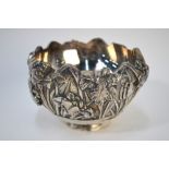 A Japanese white metal bowl, decorated on the exterior with a floral design; 13cm diameter,