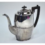 A late Victorian heavy quality silver oval half-reeded coffee pot with ebony finial and handle,