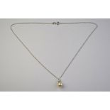 A cultured pearl pendant having three small diamonds below hanger,