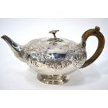A George III silver teapot of compressed melon form, with floral finial,