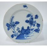An 18th century English Delft blue and white plate decorated in the Chinoiserie style with rocks,
