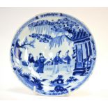 A Chinese blue and white saucer dish, decorated with a Scholar and two ladies in a narrative scene,