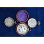 Two gilt brass pocket barometer, to/w another later example stamped for Negretti & Zambra,