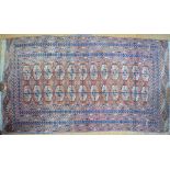 An antique Turkoman rug, the crimson-red ground with design of two rows of guls,