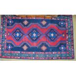 A Persian Hamadan rug, the geometric diamond pale design on red and blue ground,