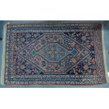 An antique Persian Hamadan mat, the coral and blue ground centred by a diamond motif,