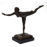 A brown patinated bronze figure of a naked female dancer in arabesque,
