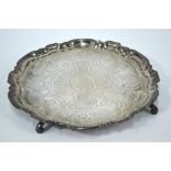 A Georgian silver salver with pie-crust rim and scroll feet, later engraved decoration,