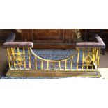An Arts & Crafts period brass club fender with studded brown leather corner seats,