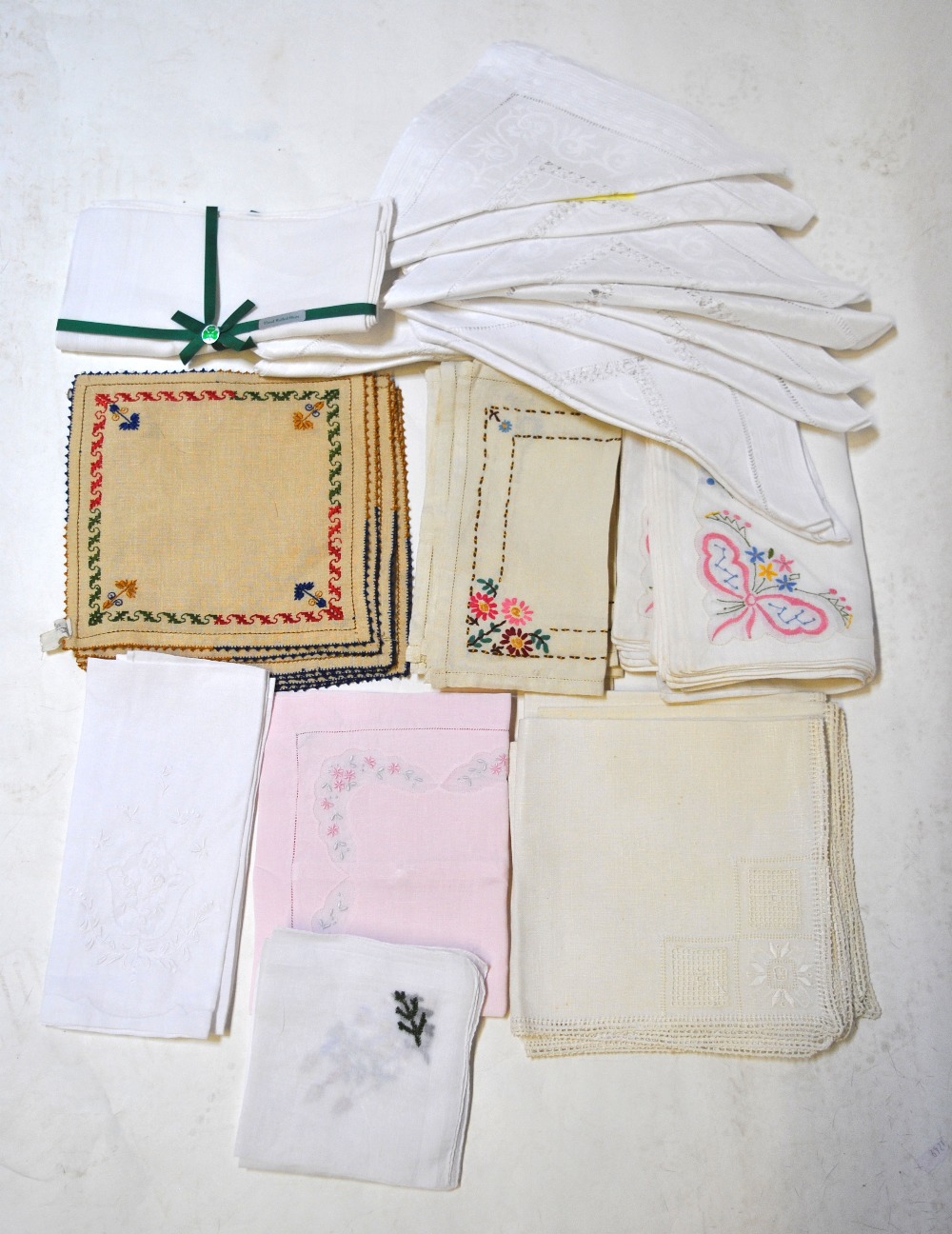 A set of twelve large white linen napkins, an embroidered set of eight table napkins,