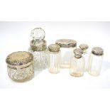 An Edwardian part travelling toiletry set with planished-design silver mounts,